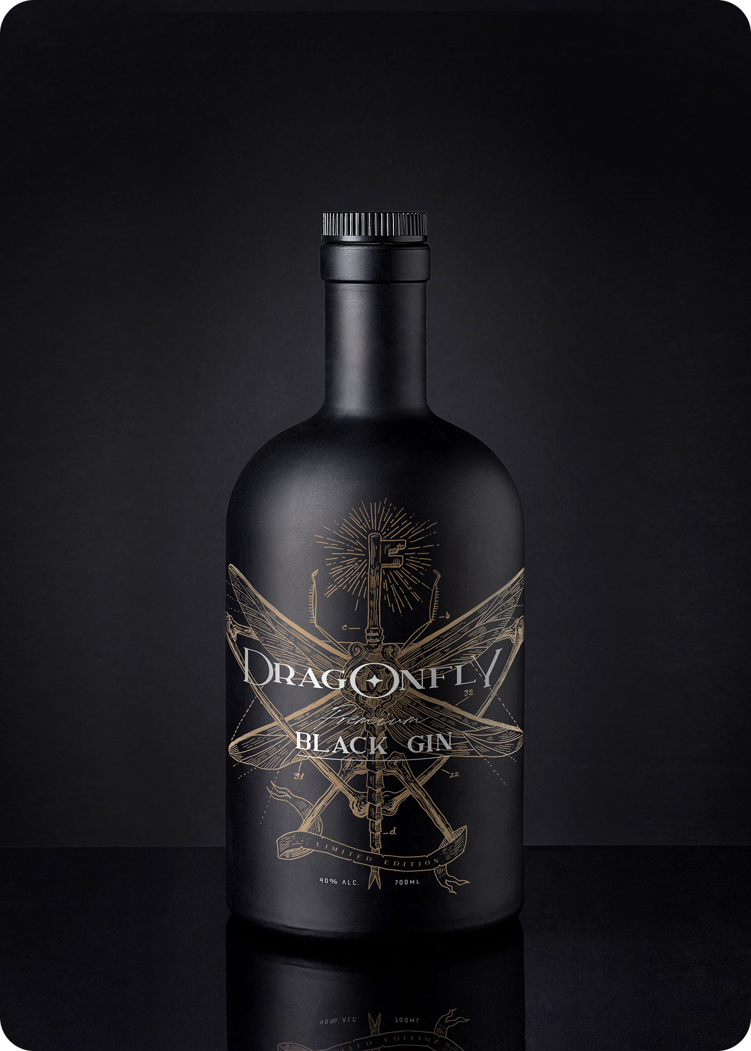 Botella de Dragonfly Black Gin con etiqueta ilustrada en dorado sobre fondo oscuro.